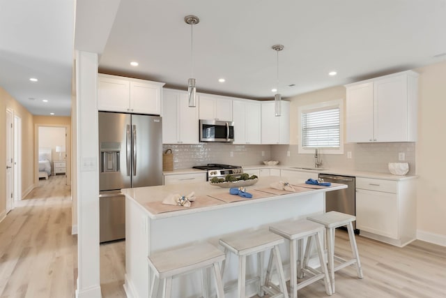 120 W 1st Ave Unit 1, North Wildwood, NJ 08260 - kitchen featuring appliances with stainless steel finishes, light wood-style floors, a kitchen island, backsplash, and recessed lighting