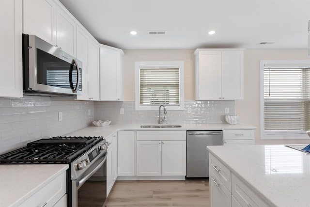 120 W 1st Ave Unit 1, North Wildwood, NJ 08260 - kitchen featuring stainless steel appliances, white cabinets, decorative backsplash, and recessed lighting