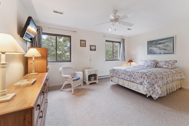 carpeted bedroom featuring multiple windows, a baseboard radiator, and ceiling fan