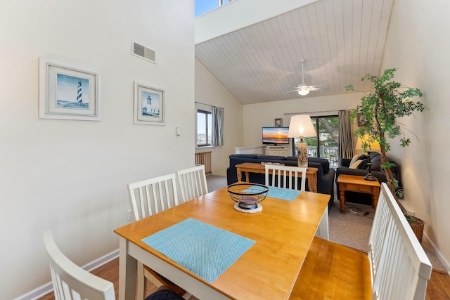 dining area featuring ceiling fan, light hardwood / wood-style floors, wood ceiling, and high vaulted ceiling