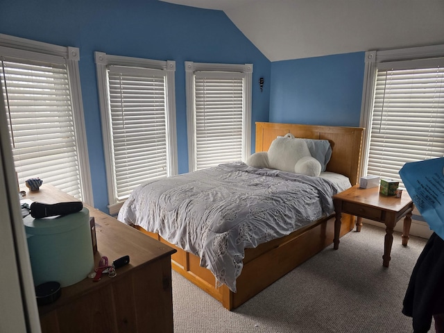 carpeted bedroom featuring vaulted ceiling and multiple windows