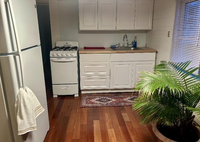 kitchen featuring a sink, light countertops, dark wood-style floors, white appliances, and white cabinetry
