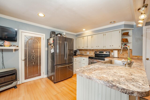 kitchen featuring appliances with stainless steel finishes, light countertops, a peninsula, and heating unit