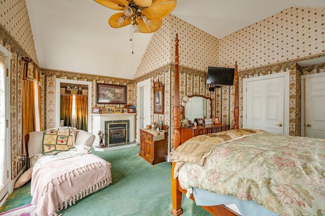 bedroom with ceiling fan, high vaulted ceiling, carpet, a glass covered fireplace, and wallpapered walls