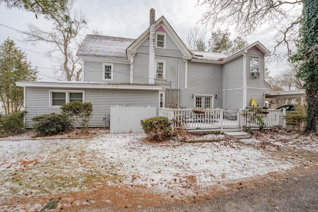 rear view of property featuring a chimney, fence, and a deck