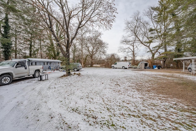 yard covered in snow featuring a storage unit and an outbuilding