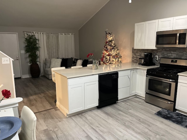 kitchen with white cabinetry, kitchen peninsula, appliances with stainless steel finishes, and tasteful backsplash