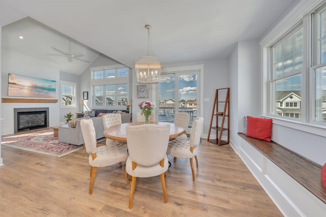 243 87th St, Stone Harbor, NJ 08247 - dining space with a chandelier, wood finished floors, a fireplace, ceiling fan, and lofted ceiling