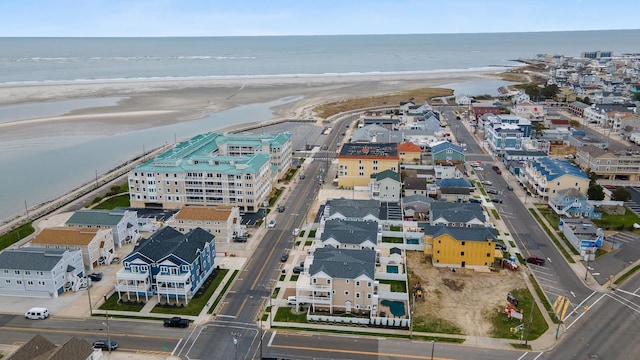 bird's eye view with a water view and a beach view