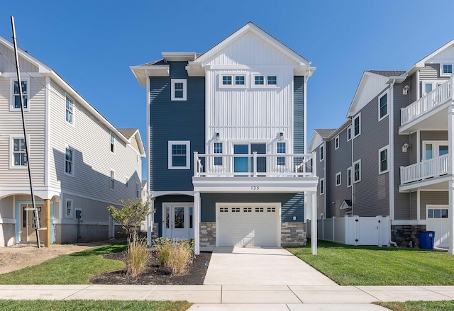 view of front of home featuring a balcony, a garage, and a front lawn