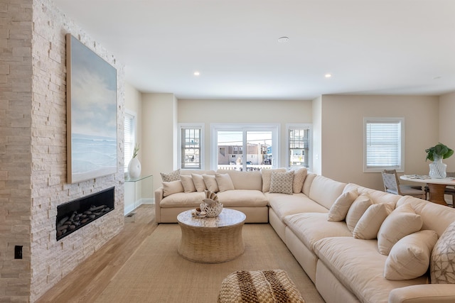 living room with a wealth of natural light, a fireplace, and light hardwood / wood-style flooring