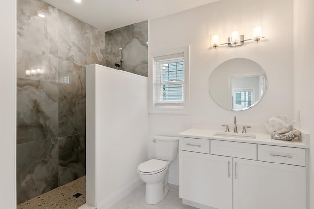 bathroom featuring vanity, toilet, and a tile shower