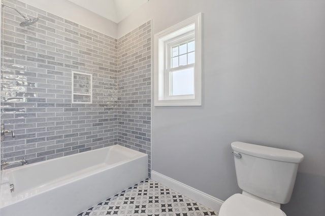 bathroom featuring tiled shower / bath and toilet