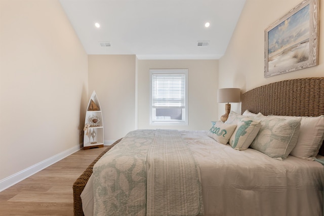 bedroom featuring lofted ceiling and light hardwood / wood-style floors