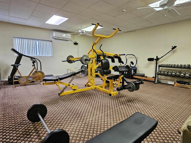 exercise room with a wall unit AC and ceiling fan