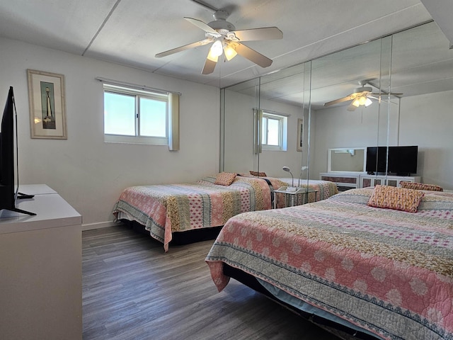 bedroom featuring multiple windows, dark hardwood / wood-style flooring, and ceiling fan