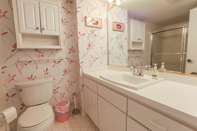 bathroom with toilet, vanity, tile patterned floors, a shower with shower door, and a textured ceiling