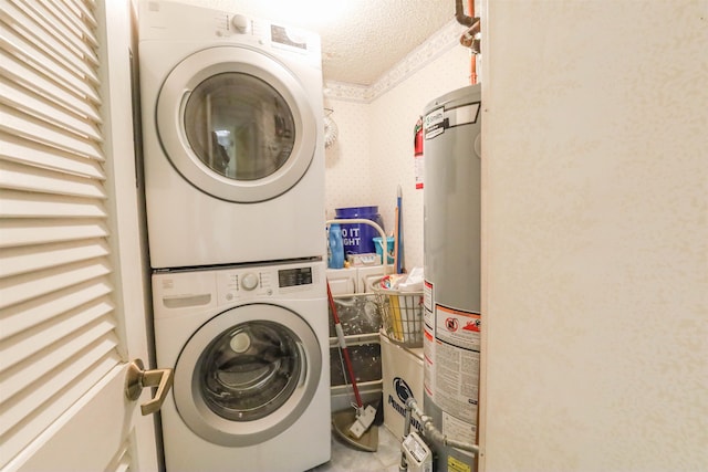 clothes washing area with water heater, a textured ceiling, and stacked washer and clothes dryer