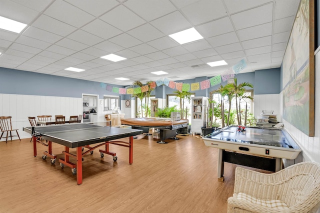 recreation room featuring light hardwood / wood-style floors and a drop ceiling