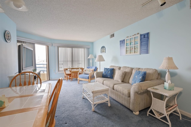 living room with a textured ceiling and carpet flooring