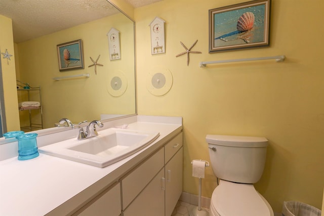 bathroom featuring a textured ceiling, toilet, tile patterned flooring, and vanity