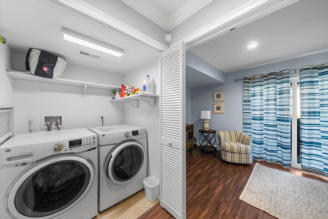 clothes washing area featuring crown molding, washing machine and dryer, and dark wood-type flooring