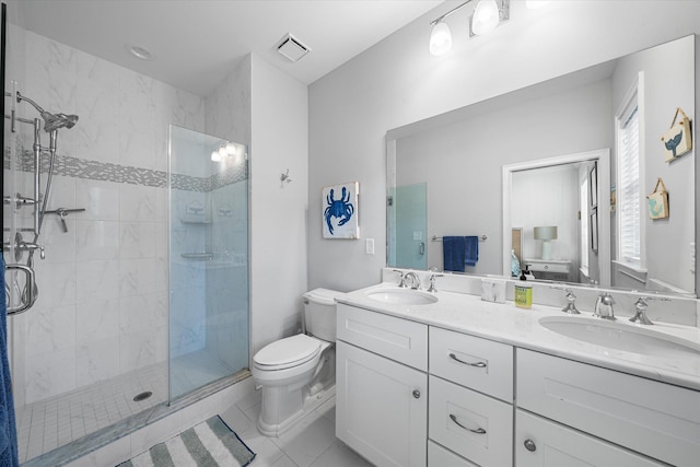 bathroom with toilet, a tile shower, vanity, and tile patterned floors