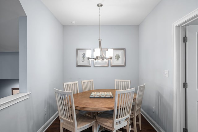 dining area with dark hardwood / wood-style floors and a chandelier