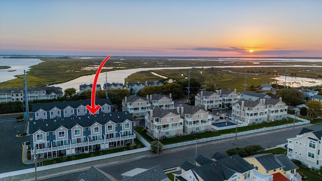 aerial view at dusk featuring a water view