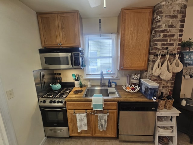 kitchen with sink, stainless steel appliances, and light tile patterned flooring