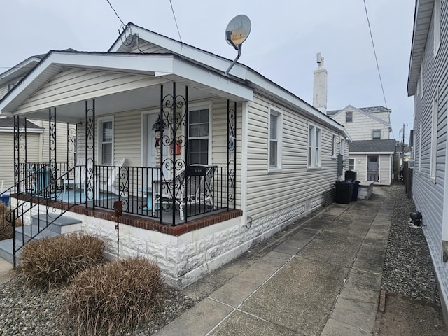 view of front of property featuring a storage unit and covered porch