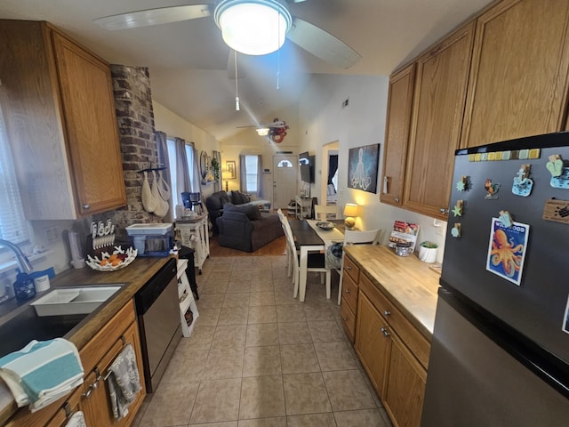 kitchen with butcher block countertops, light tile patterned floors, sink, and appliances with stainless steel finishes