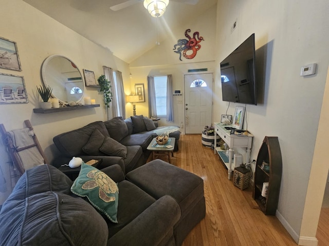 living room with high vaulted ceiling, ceiling fan, and light wood-type flooring