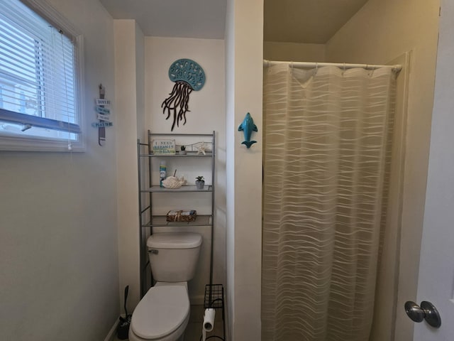 bathroom featuring curtained shower and toilet