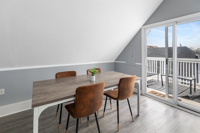 dining area featuring lofted ceiling, wood finished floors, and baseboards