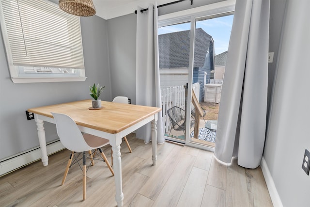 dining area featuring light wood-type flooring, plenty of natural light, and baseboards