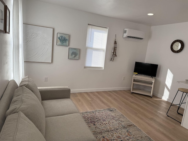 living room featuring a wall unit AC, baseboards, wood finished floors, and recessed lighting