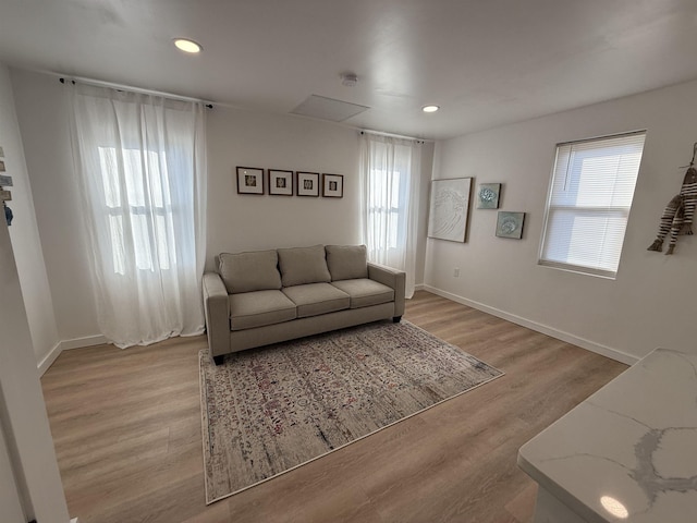 living room with recessed lighting, light wood-style flooring, and baseboards