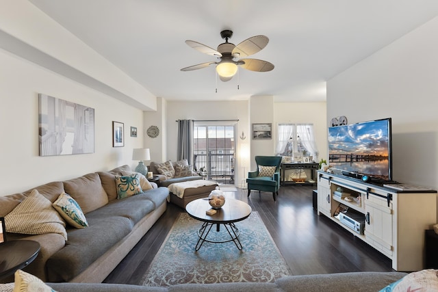 living room with ceiling fan and dark wood-type flooring