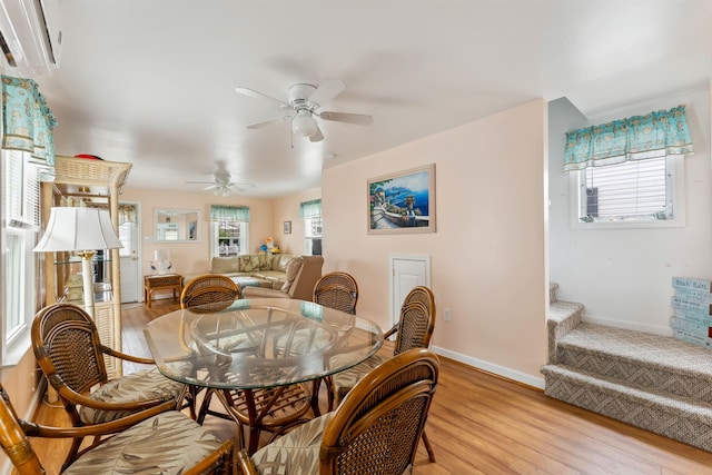 214 W 12th Ave, North Wildwood, NJ 08260 - dining space featuring a ceiling fan, an AC wall unit, light wood-style flooring, and stairs