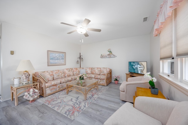 living room featuring ceiling fan, wood finished floors, and visible vents