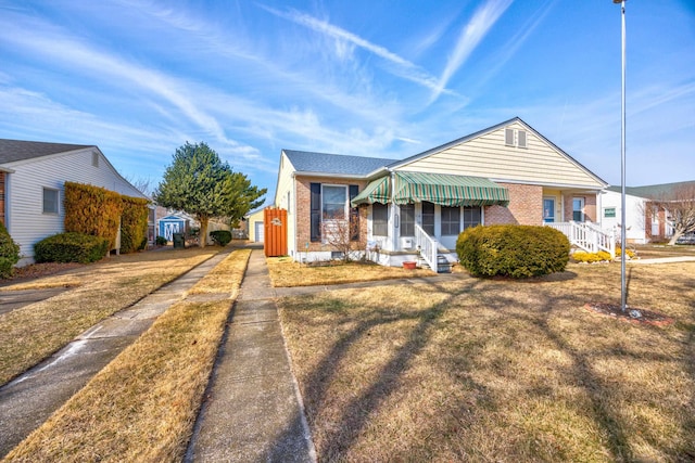 bungalow-style home with a front yard and brick siding