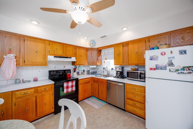 kitchen featuring stainless steel appliances, visible vents, brown cabinetry, a sink, and under cabinet range hood