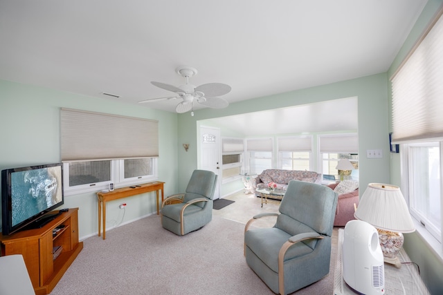 living area with carpet floors, visible vents, and a ceiling fan