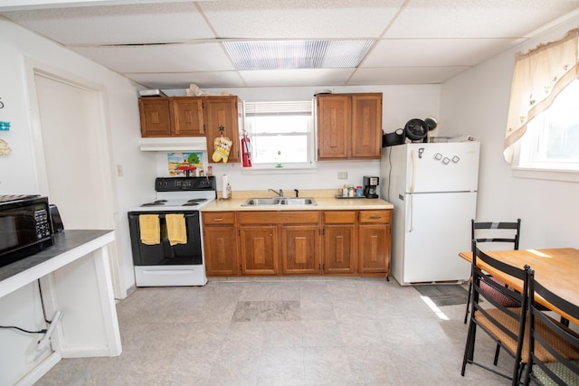 kitchen with white appliances, a drop ceiling, and sink