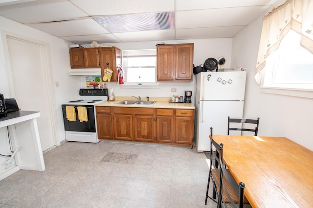 kitchen with white appliances, a paneled ceiling, and sink