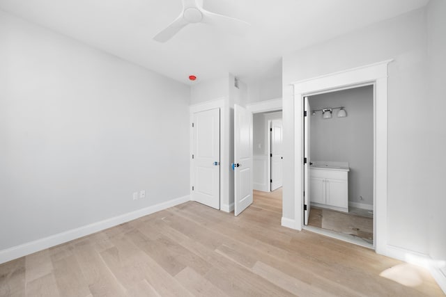 unfurnished bedroom with ensuite bathroom, ceiling fan, and light wood-type flooring