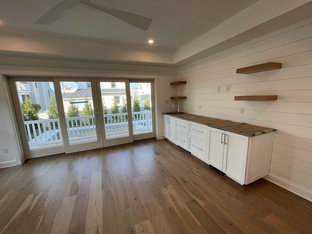 interior space with white cabinetry, wood counters, sink, and dark hardwood / wood-style flooring