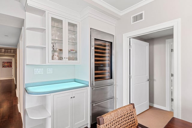 kitchen with wine cooler, white cabinets, and ornamental molding