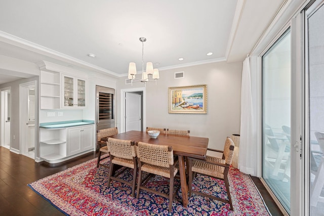 dining room with crown molding, a chandelier, and dark hardwood / wood-style floors